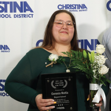 Photo of Genesia Mattia the Bayard School 2025-2026 Teacher of the year holding plaque and flowers